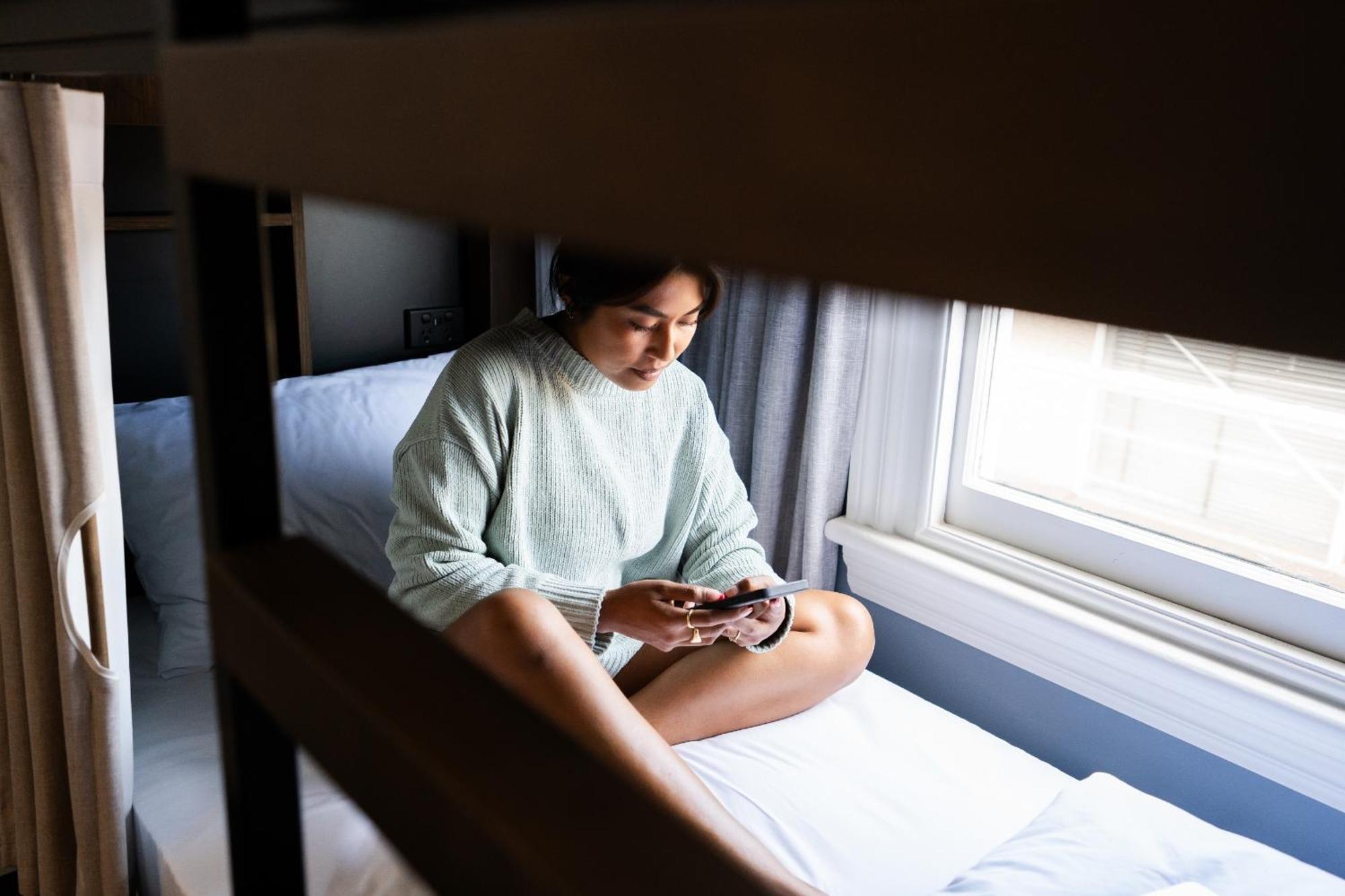 Haka House Christchurch Quarto foto A woman sitting on a bunk bed